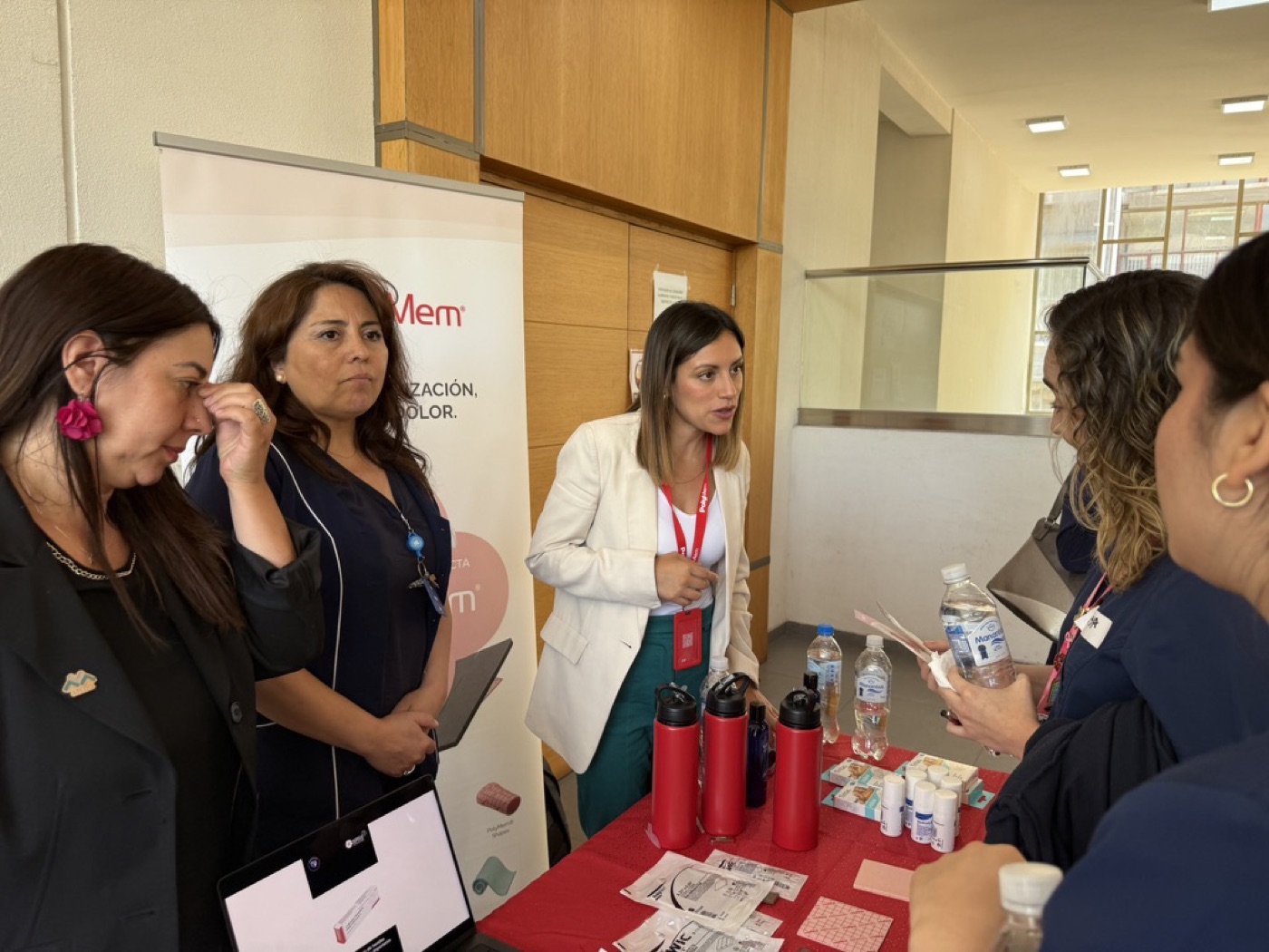 Jocelyn conversando con profesionales en stand clínico